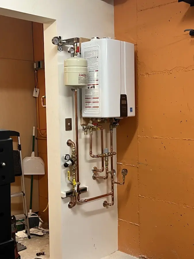 Plumbing technician inspecting water heater connections in Tracy